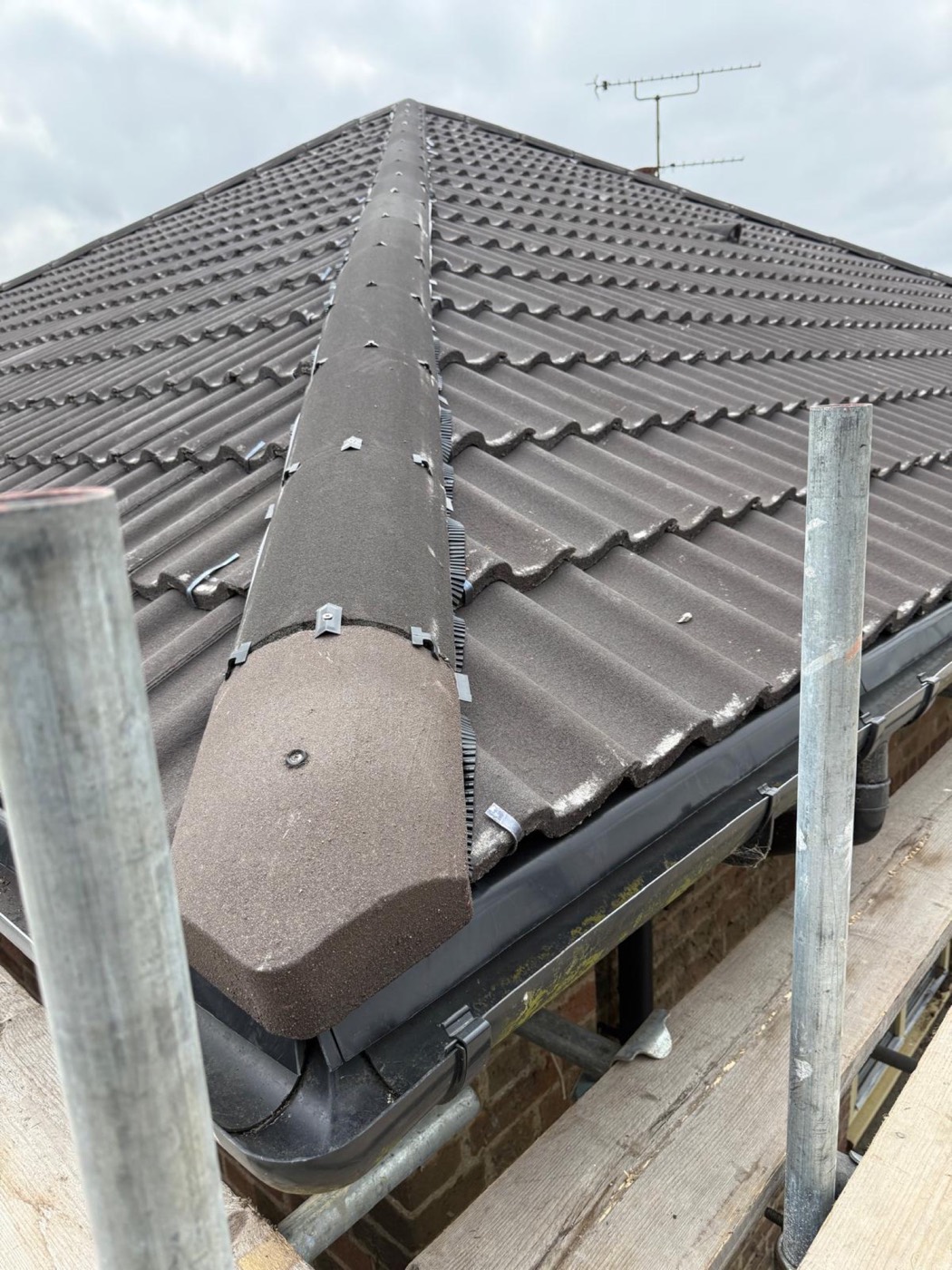 New hipped roof with dry-fix hips running down to fresh black PVC guttering