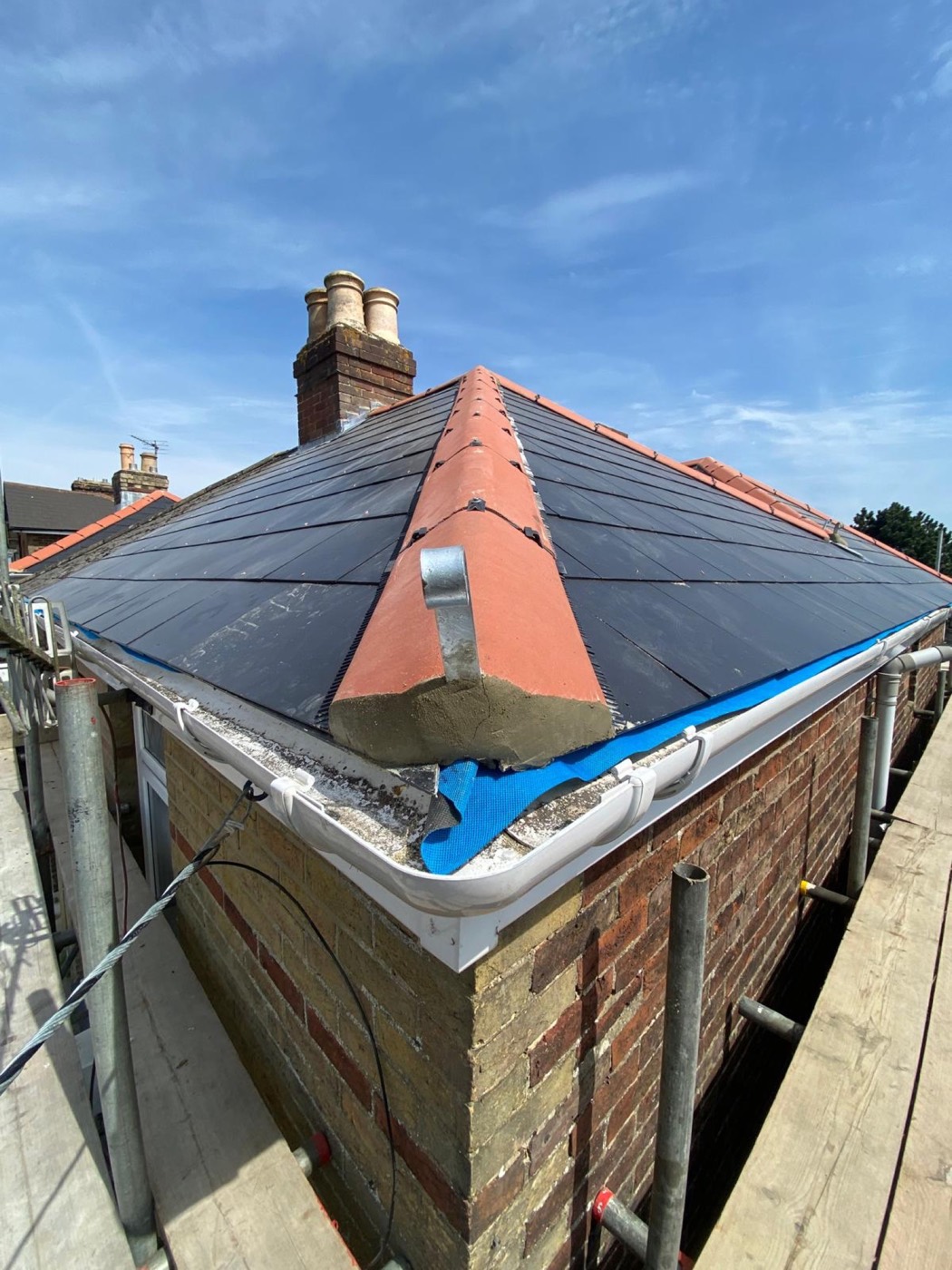 Finished slate hipped roof with brand new white PVC fascia and gutter at the eaves