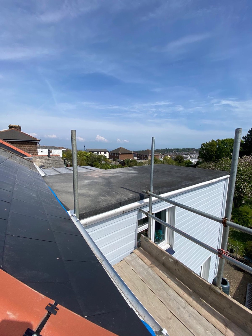 Completed felt flat roof on a dormer extension with new white uPVC gutter and fascia