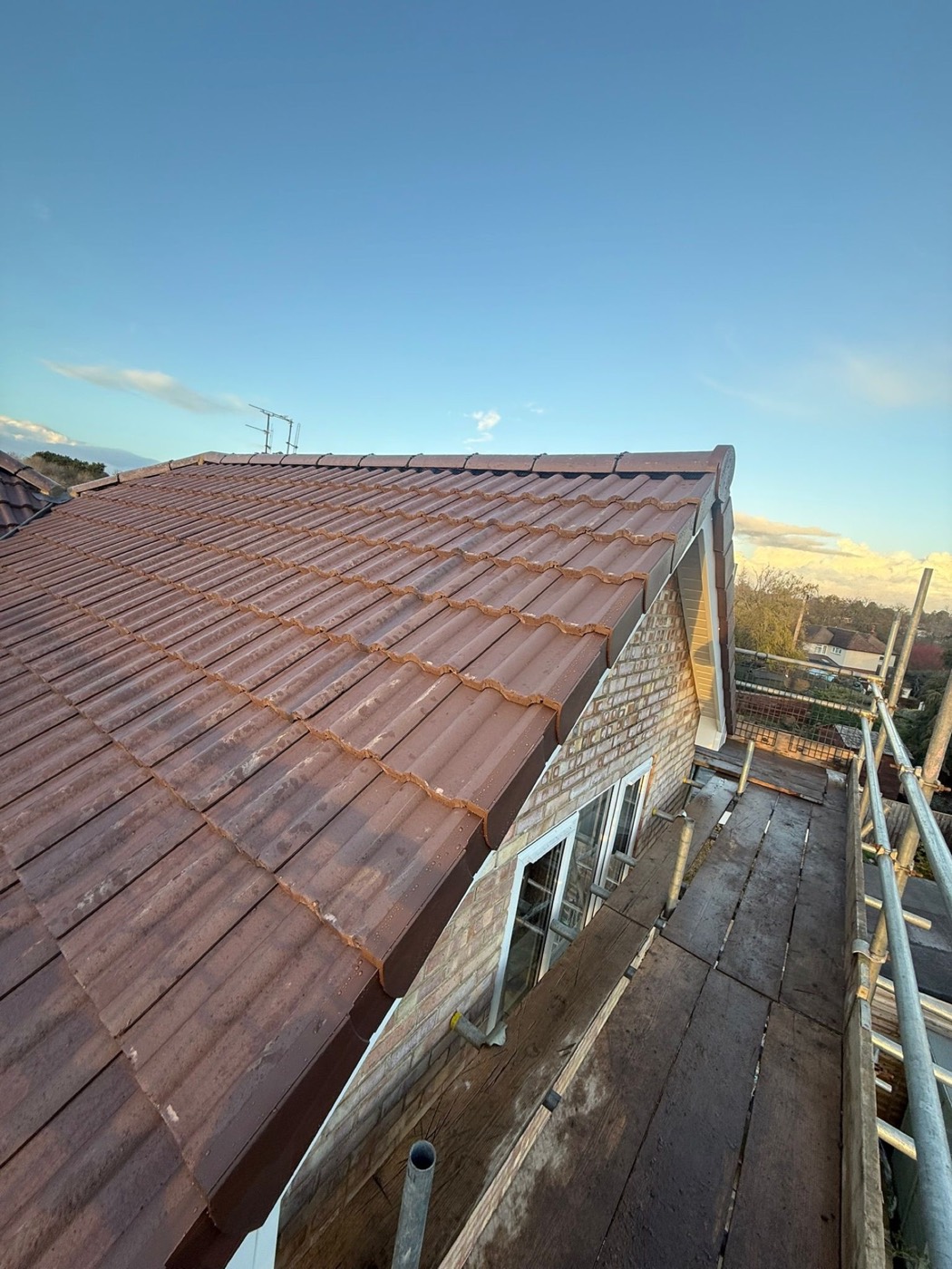 Completed interlocking concrete tile roof with a dry-fix ridge and clean gable verge