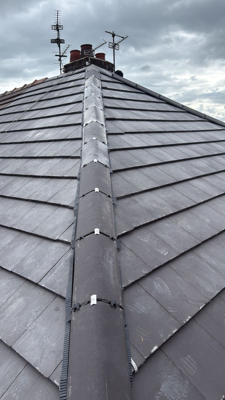 Completed slate hipped roof shot up the hip, with dry-fix hip caps and clips